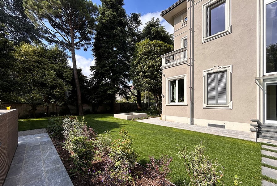Villa storica ristrutturata con facciata classica e giardino spazioso
