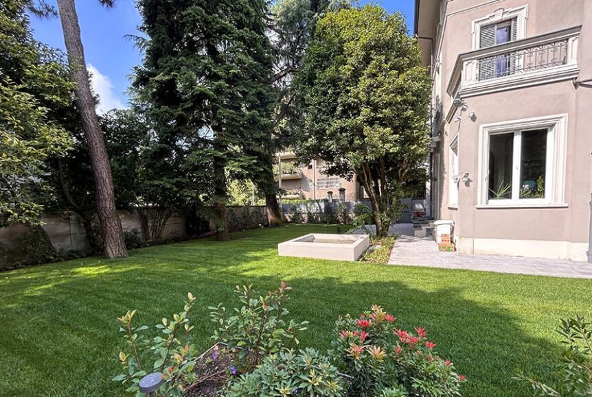 Villa storica ristrutturata con facciata classica e giardino spazioso