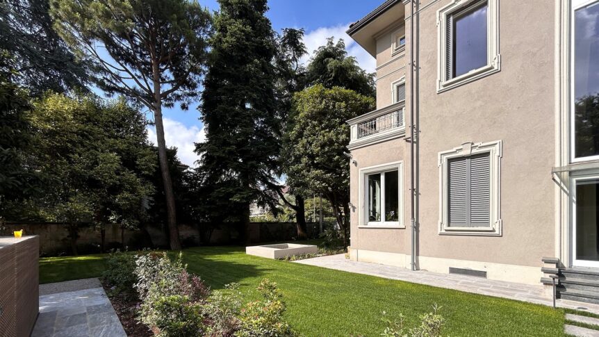 Villa storica ristrutturata con facciata classica e giardino spazioso